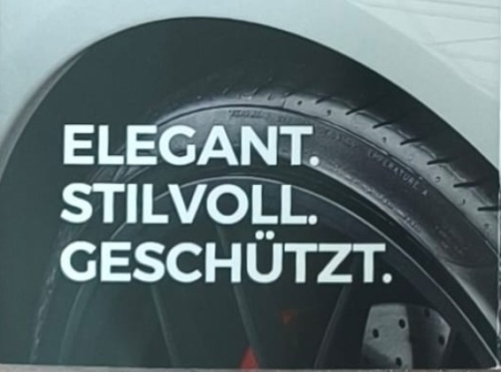 Rad und Kotflügel eines Fahrzeugs mit dem Schriftzug Elegant. Stilvoll. Geschützt.